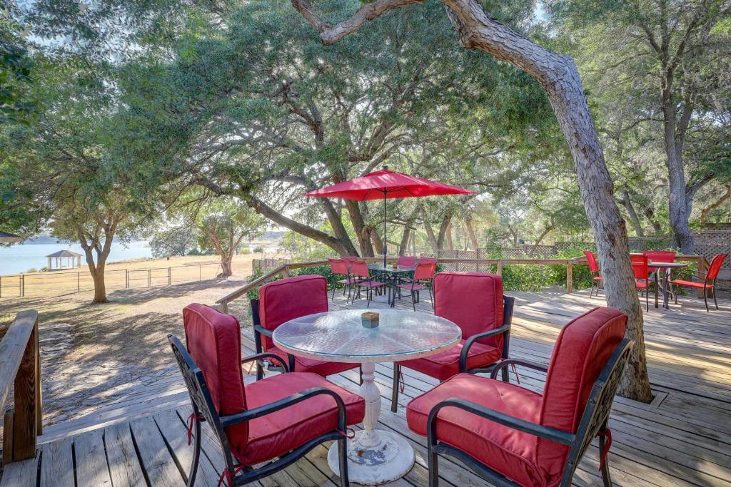 a table with chairs and an umbrella on a deck at Temple Retreat with Cliffside Belton Lake Views! in Temple