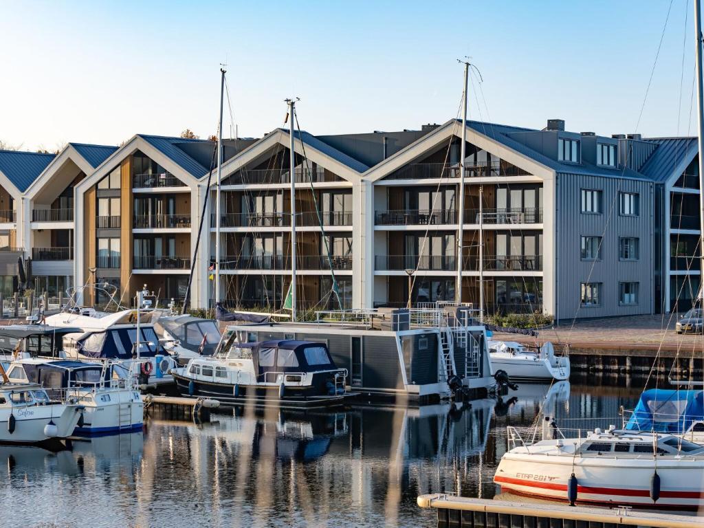 a marina with boats in front of a large building at Beautiful apartment with beautiful views of the lively marina in Kamperland