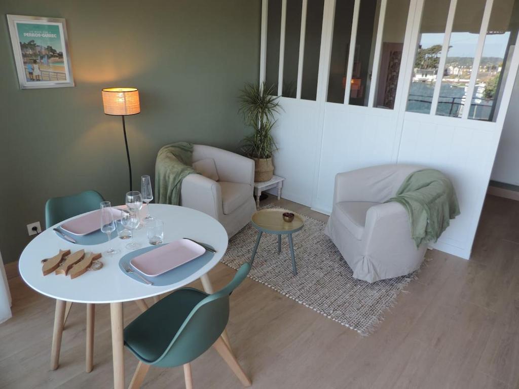 un salon avec une table et des chaises blanches dans l'établissement LE HAVRE DE BABOU, à Perros-Guirec