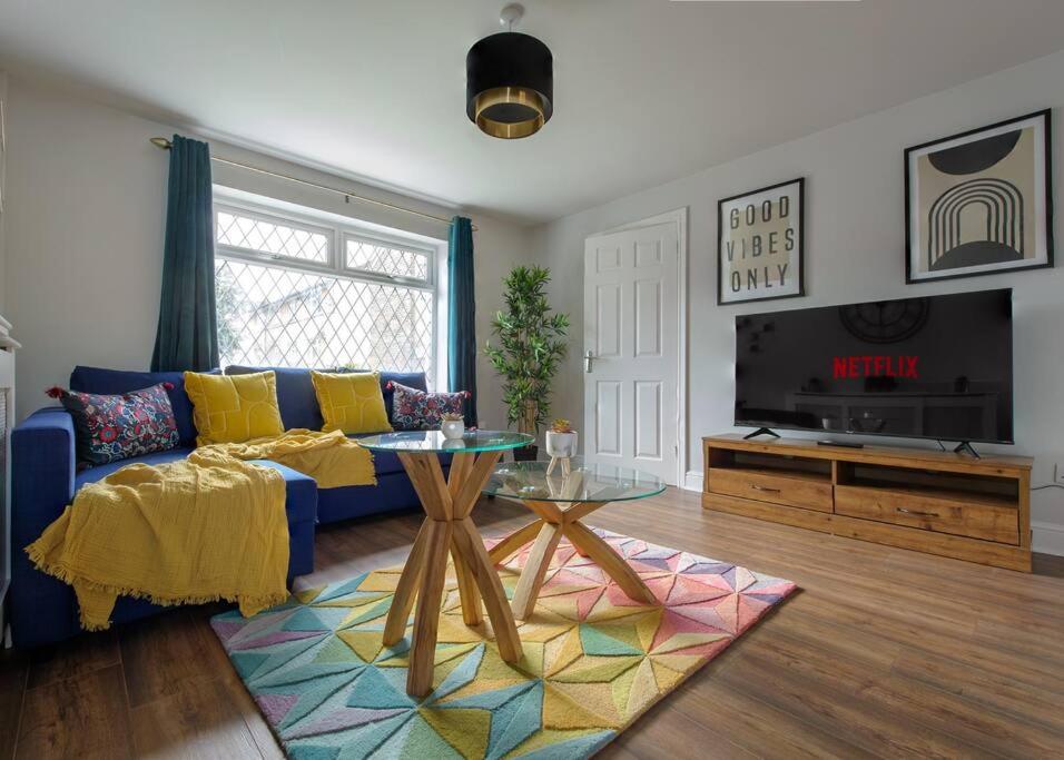 a living room with a blue couch and a tv at Modern House w/Terrace in Nottingham FREE Parking in Nottingham