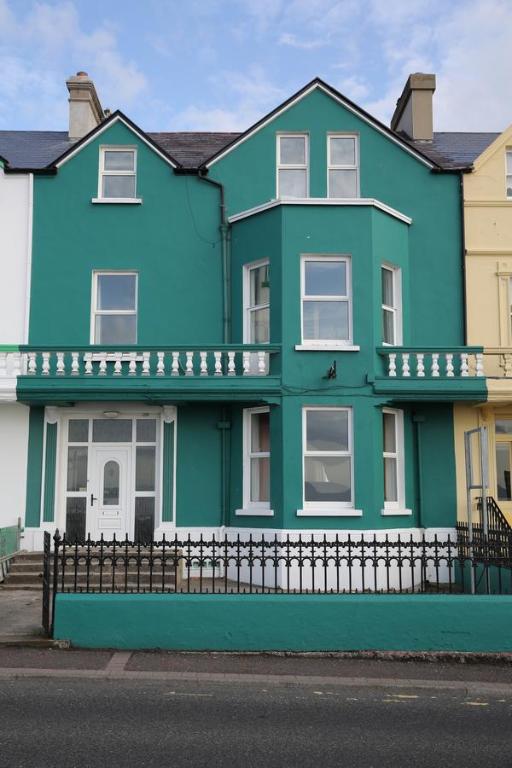 una casa azul con una valla negra delante de ella en Rolling Wave Guesthouse, en Bundoran