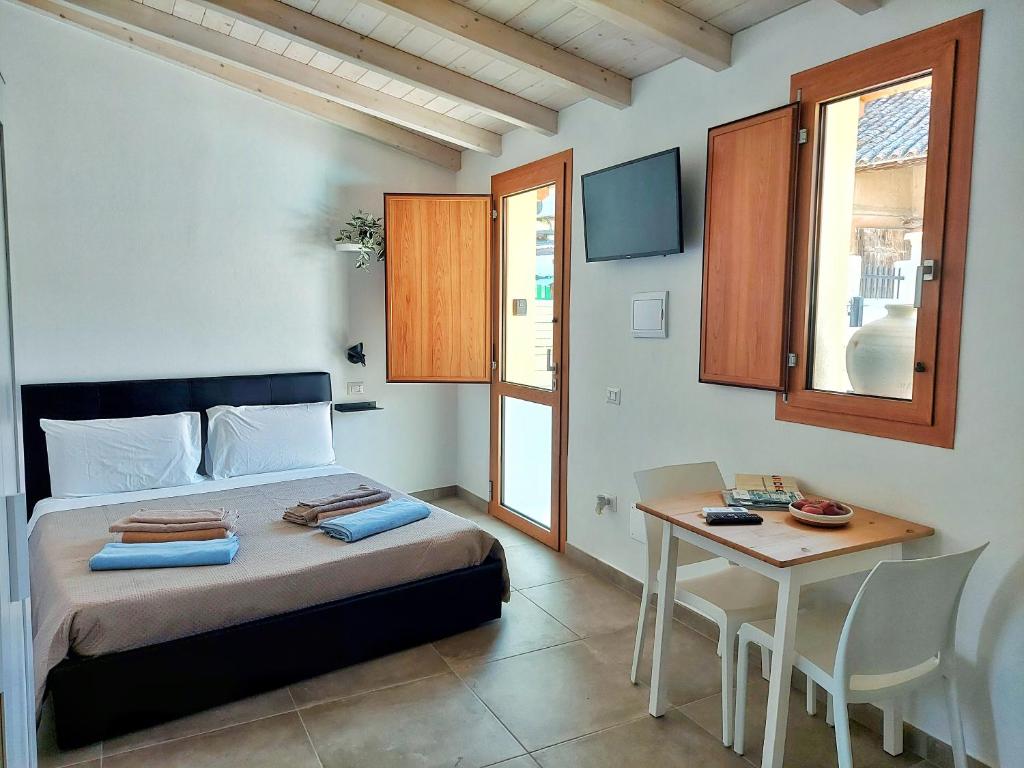 Schlafzimmer mit einem Bett, einem Tisch und einem Schreibtisch in der Unterkunft Villa Campidanese in Assemini