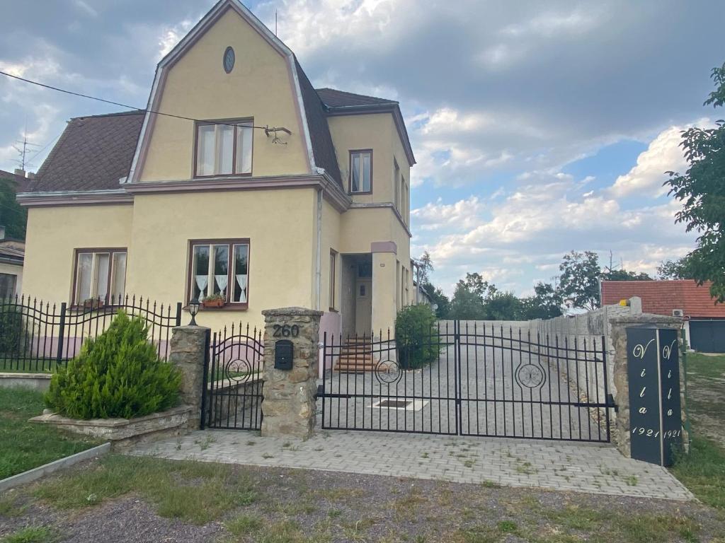 una casa blanca con una puerta y una valla en Vila 1921 en Jevišovice