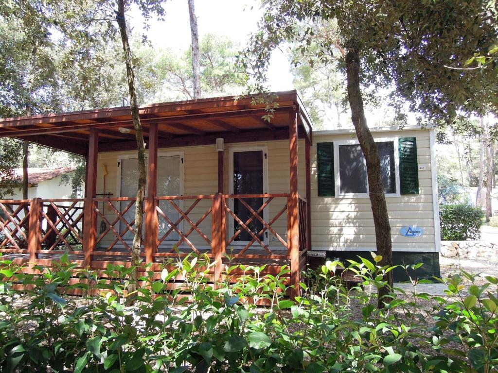 a tiny house in the woods with a porch at Comfortable chalet with two bathrooms at 31 km from Zadar in Biograd na Moru