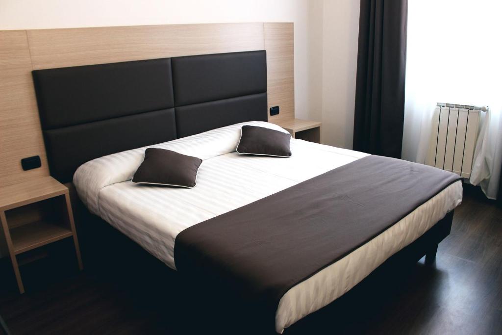 佛羅倫斯的住宿－埃斯佩蘭薩酒店，一间卧室配有一张大床和两个枕头