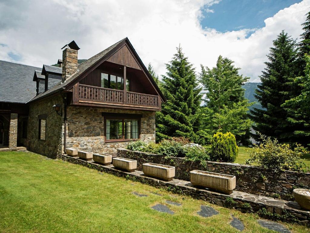 a stone house with a balcony on top of a yard at Splendid house next to the Baqueira Beret ski resort in Vielha