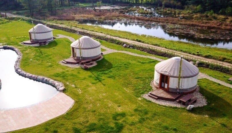 uma vista aérea de três cúpulas num campo com um lago em Ale-Wioska 
