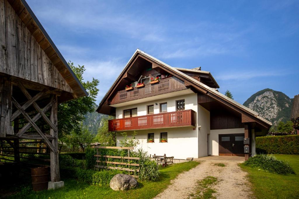 a large white house with a wooden roof at Apartma Ivano in Bohinj
