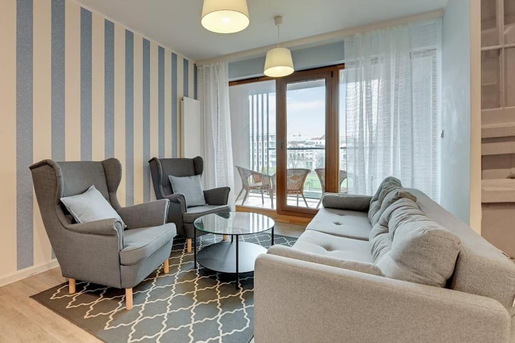 ein Wohnzimmer mit einem Sofa, 2 Stühlen und einem Tisch in der Unterkunft Central Apartments T15/15 in Danzig