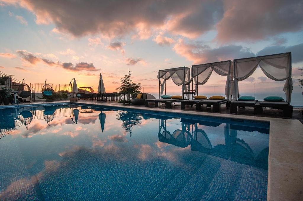 une piscine avec vue sur le coucher du soleil en arrière-plan dans l'établissement Chateau Glili, à Safed