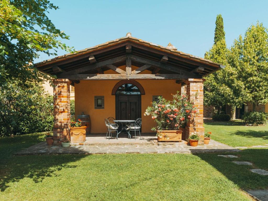 コルトーナにあるBeautiful holiday home with view over Cortona in beautiful surroundingsの庭にテーブルと椅子が備わるパビリオン