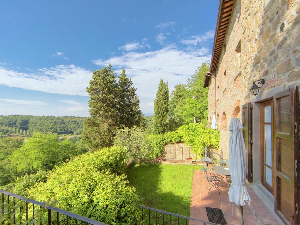 d'un balcon avec un parasol et un jardin. dans l'établissement Attractive apartment in typical Tuscan style, à Figline Valdarno