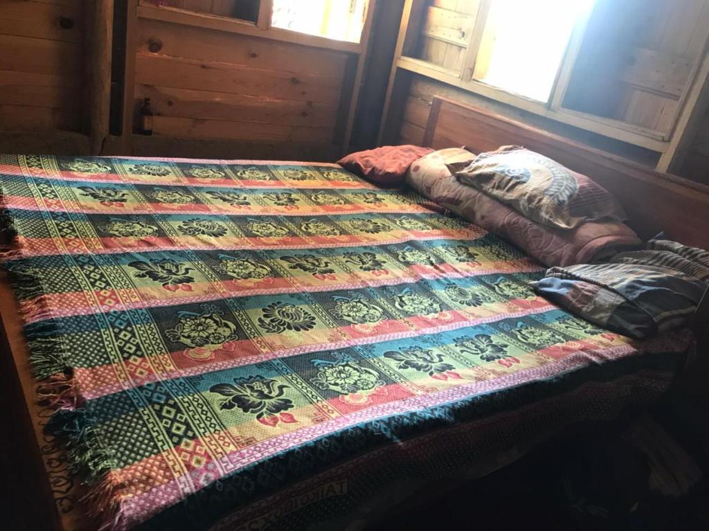 łóżko w pokoju z kołdrą w obiekcie Spiritual Nature Farm - Sri Lanka w mieście Matale
