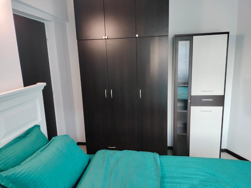 een slaapkamer met een bed en een kast bij Stefan Apart Iași centru Palas in Iaşi