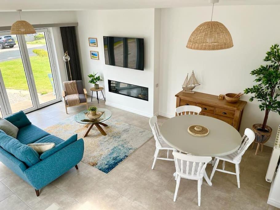 a living room with a blue couch and a table at Muckish Maison in Dunfanaghy