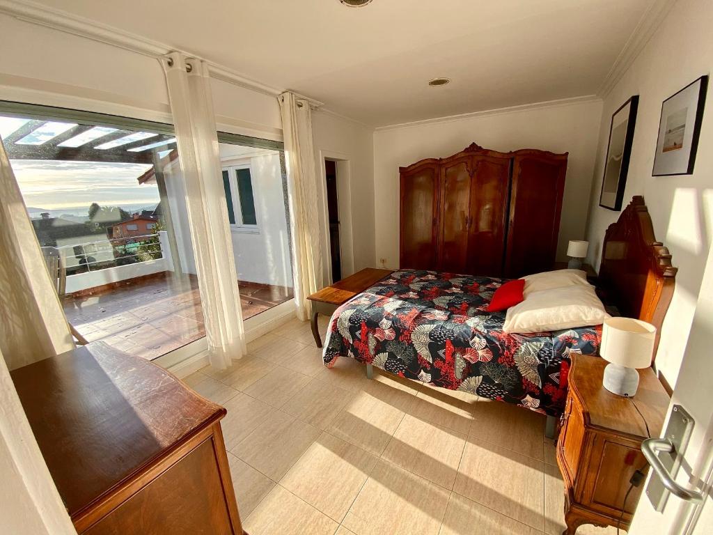 a bedroom with a bed and a balcony at Casa Rural Albores Grande Nigrán in Nigrán