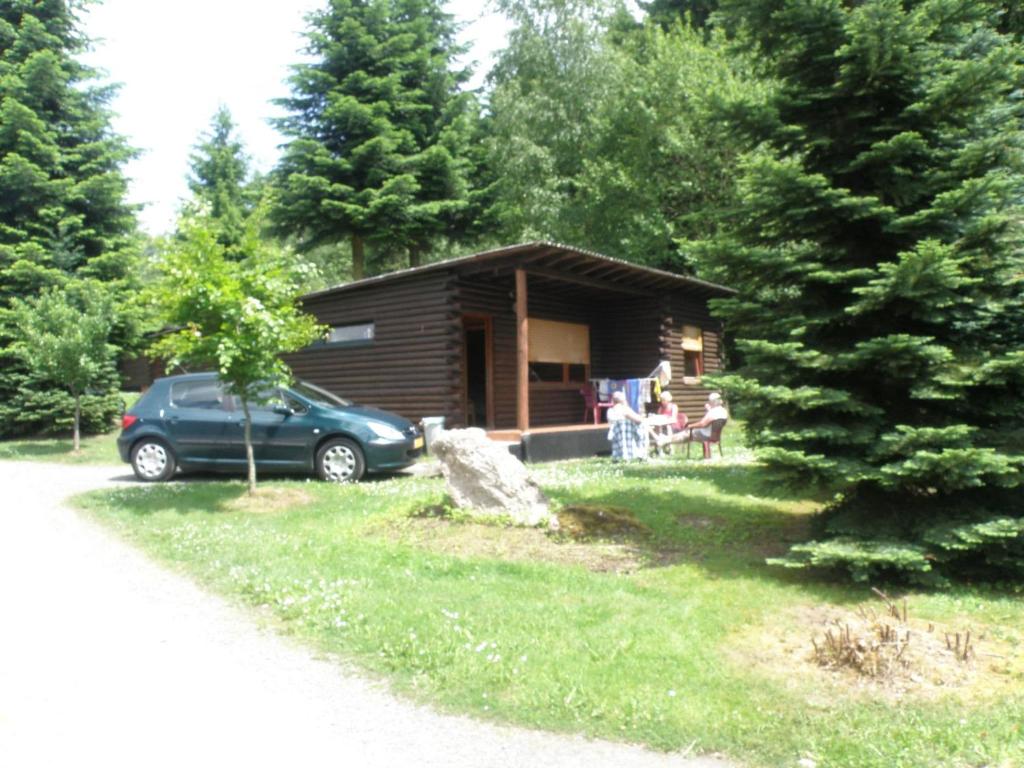 a log cabin with a car parked in front of it at Nice house with sauna and steam bath in a forest in Sellerich