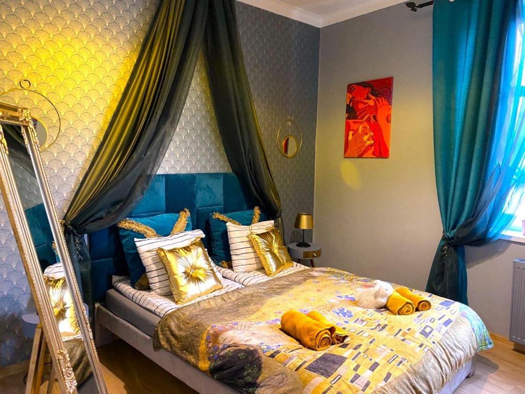 a bedroom with a bed with yellow pillows on it at Gold room in Krakow