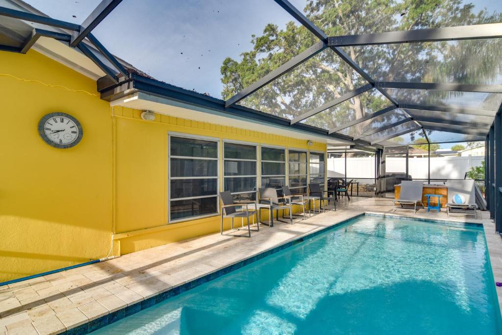 uma casa amarela com piscina e relógio em Largo Home with Pool and Hot Tub 4 Mi to Beach! em Largo