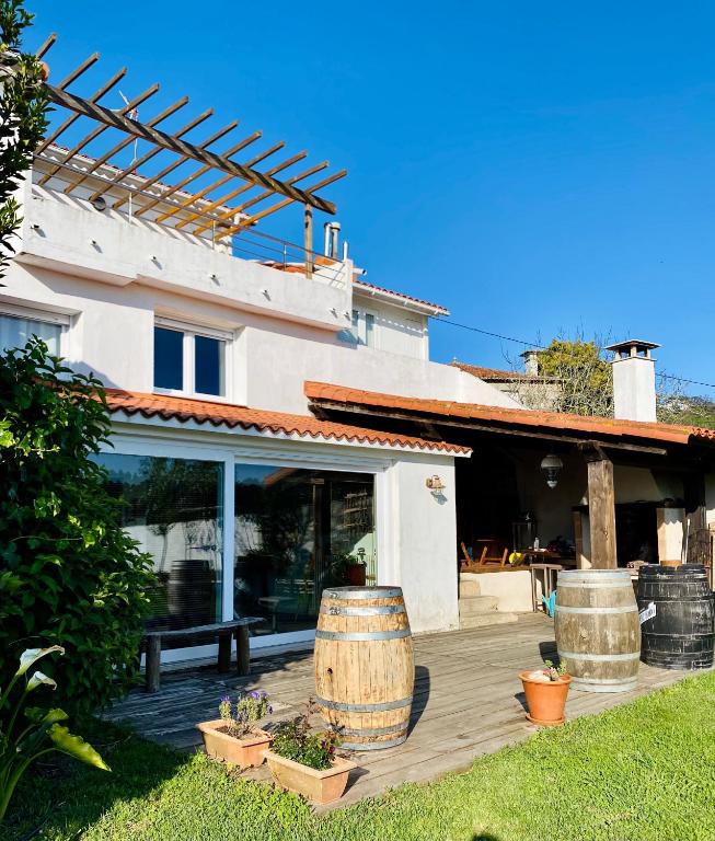 a house with a wooden deck with two large barrels at Casa Rural Albores Grande Nigrán in Nigrán
