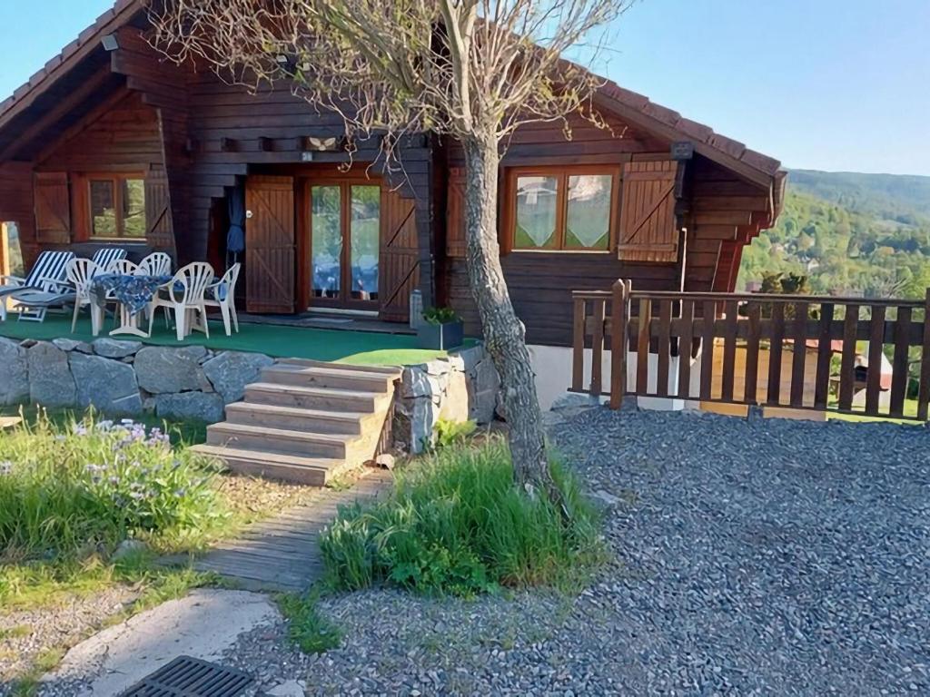 a log cabin with a table and chairs in front of it at Nice Chalet with sauna in Vosges in Saint-Maurice-sur-Moselle