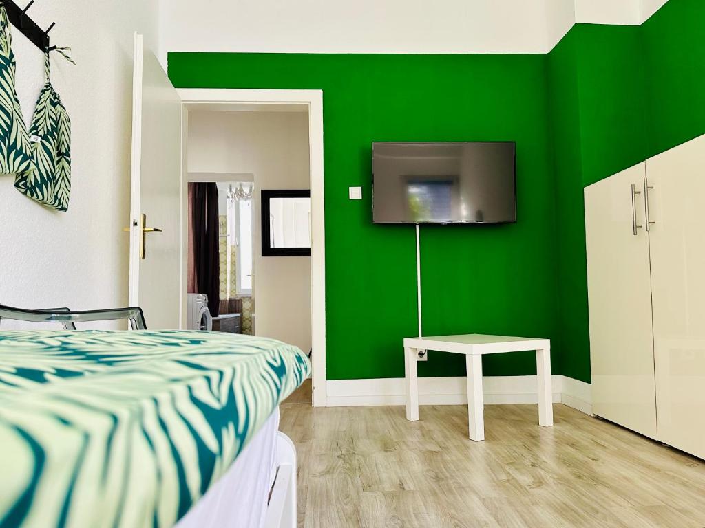 sypialnia z zieloną ścianą z łóżkiem i stołem w obiekcie FeWo Ischeland near Hagen-City w mieście Hagen