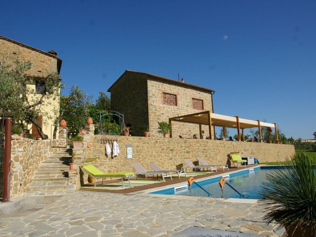 a swimming pool with lounge chairs and a building at Beautiful Holiday Home in Vinci with Swimming Pool in Vinci