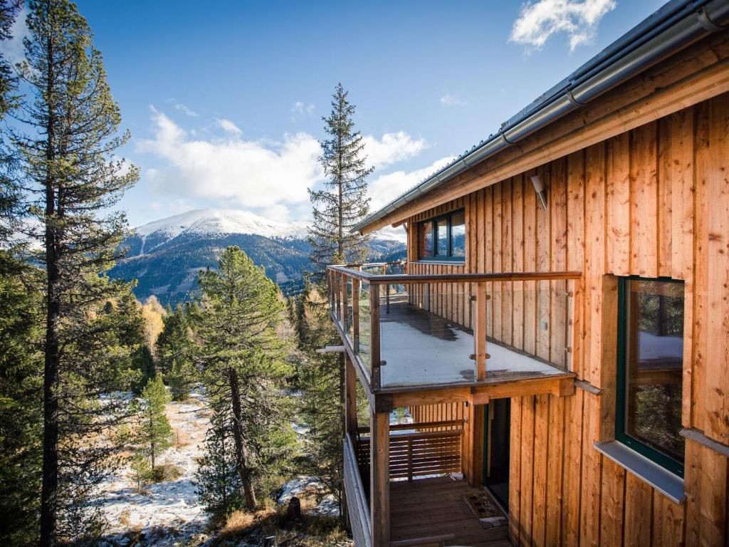 a cabin with a balcony with a view of the mountains at Lovely Chalet in Turracherh he with Sauna in Turracher Hohe