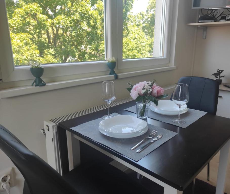 een tafel met borden, glazen en bloemen erop bij BRIGHT CITY CENTER Apartment - FlexibleCheckins in Zagreb