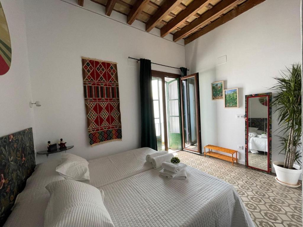 a bedroom with a bed and a large window at Doña Lola Rooms in Conil de la Frontera