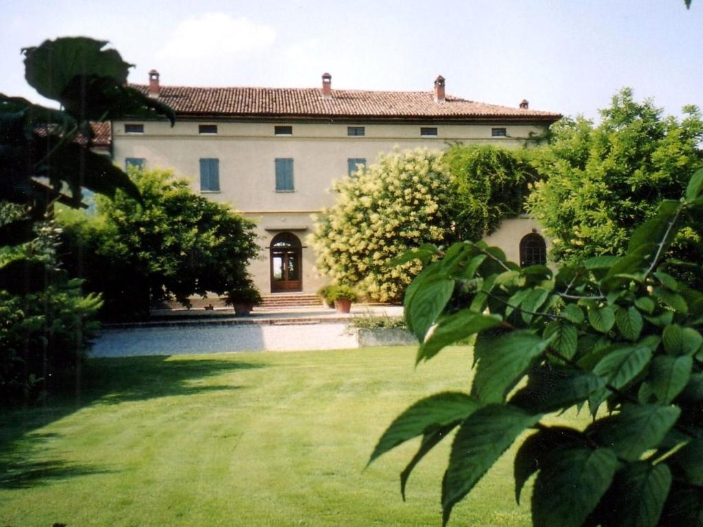 ein großes Haus mit einem großen Hof mit Gras in der Unterkunft Quaint Mansion in Stagno Lombardo with Garden in Stagno Lombardo