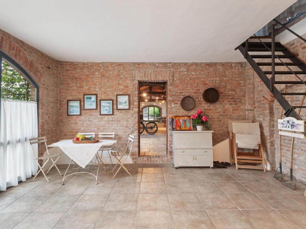 sala de estar con mesa y pared de ladrillo en Quaint Mansion in Stagno Lombardo with Garden, en Stagno Lombardo