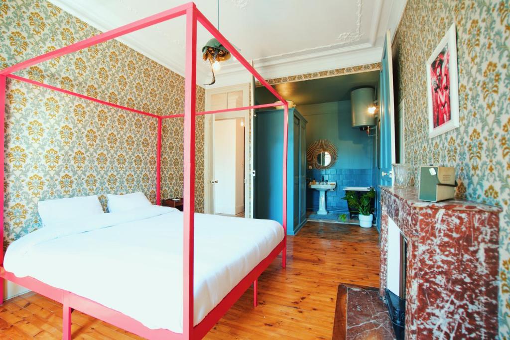 - une chambre avec un lit doté d'un cadre rouge dans l'établissement Estacart - Grenoble Centre, à Grenoble