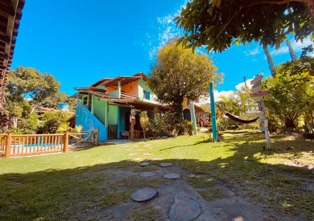 una casa con una hamaca en el patio en Caraiva Recanto Pousada de Ferias, en Caraíva