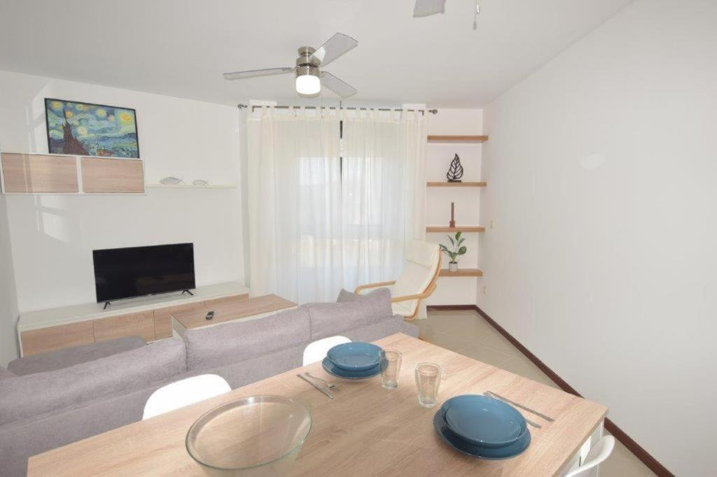 een woonkamer met een tafel en een bank bij Apartamento Antia in Fisterra