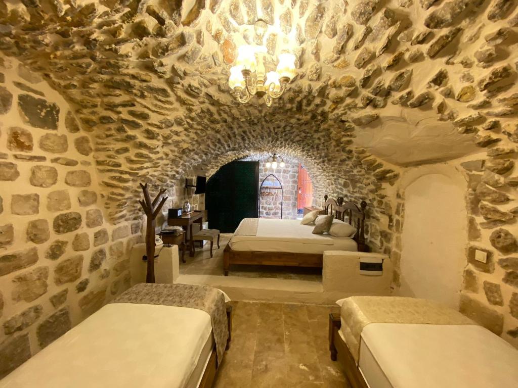 a bedroom with two beds in a stone wall at Hanedan Konağı Butik Otel in Yaylacık