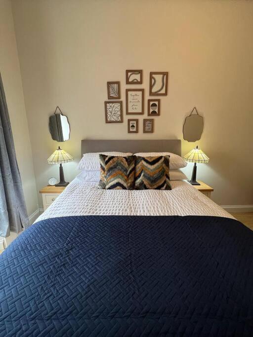 a bedroom with a large blue bed with two lamps at Luxury Victorian spacious flat in Glasgow