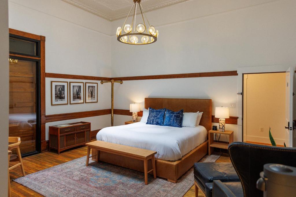 a bedroom with a large bed and a chandelier at Fire Station One Boutique Hotel in Roanoke
