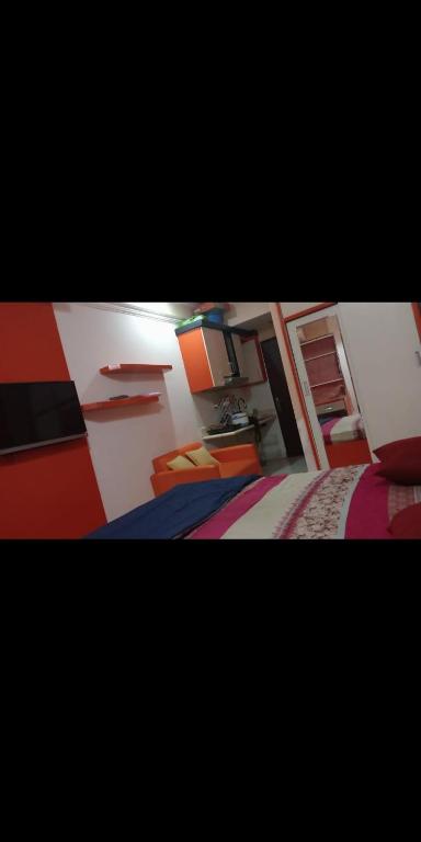 ein kleines Schlafzimmer mit 2 Betten und eine Küche in der Unterkunft Apartemen suhat in Jenggrik