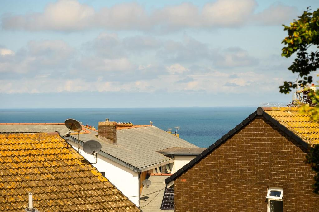 uma vista para o oceano a partir dos telhados das casas em Coastal Haven Ilfracombe by StayStaycations em Ilfracombe