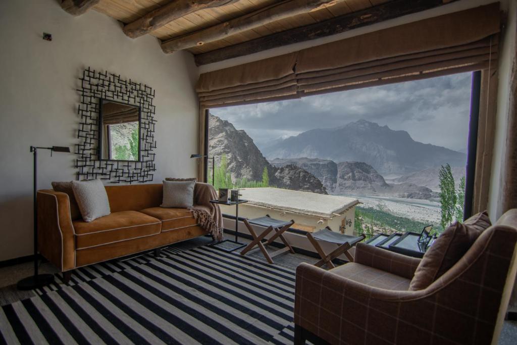 a living room with a couch and a large window at BROQ in Skardu