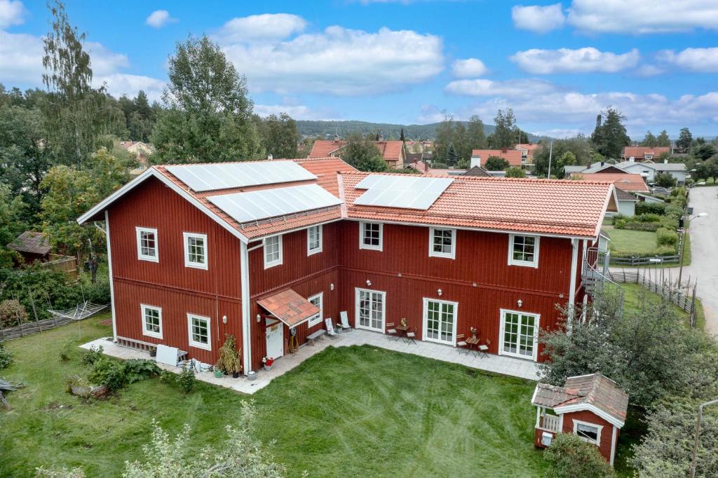 an aerial view of a red house with solar panels on it at Flygeln in Leksand