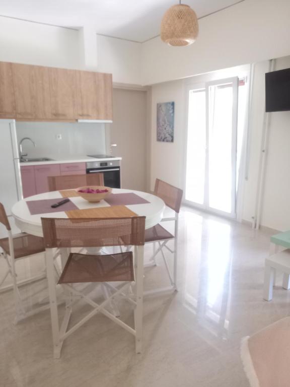eine Küche und ein Esszimmer mit einem Tisch und Stühlen in der Unterkunft Ilion apartments in Athen