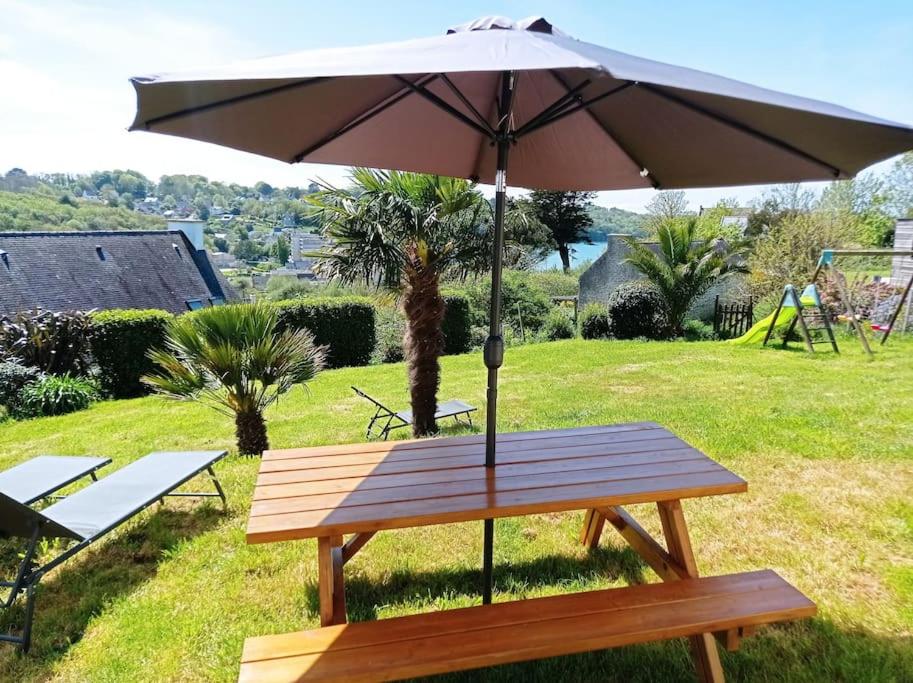un tavolo da picnic con ombrellone su un campo di Maison 12 pers Douarnenez kerlaz 2 étoiles Atout France a Kerlaz