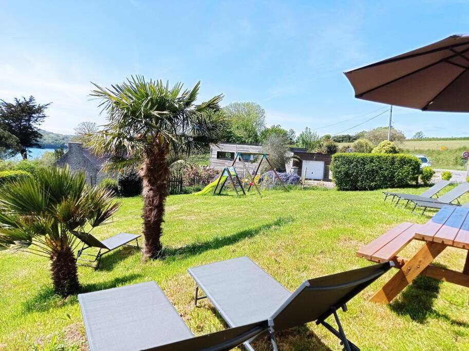 a park with chairs and an umbrella and a picnic table at Maison 12 pers Douarnenez kerlaz 2 étoiles Atout France in Kerlaz