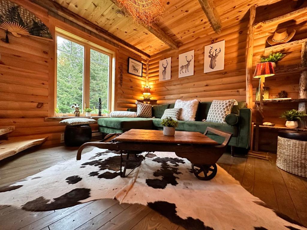 een woonkamer met een bank en een tafel in een hut bij Le Ti Moose - Les Chalets Spa Canada in La Malbaie