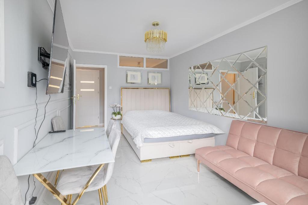 - une chambre avec un lit et un canapé dans l'établissement Gold Glamour Apartment Sopot z dwoma sypialniami, duzy balkon, à Sopot