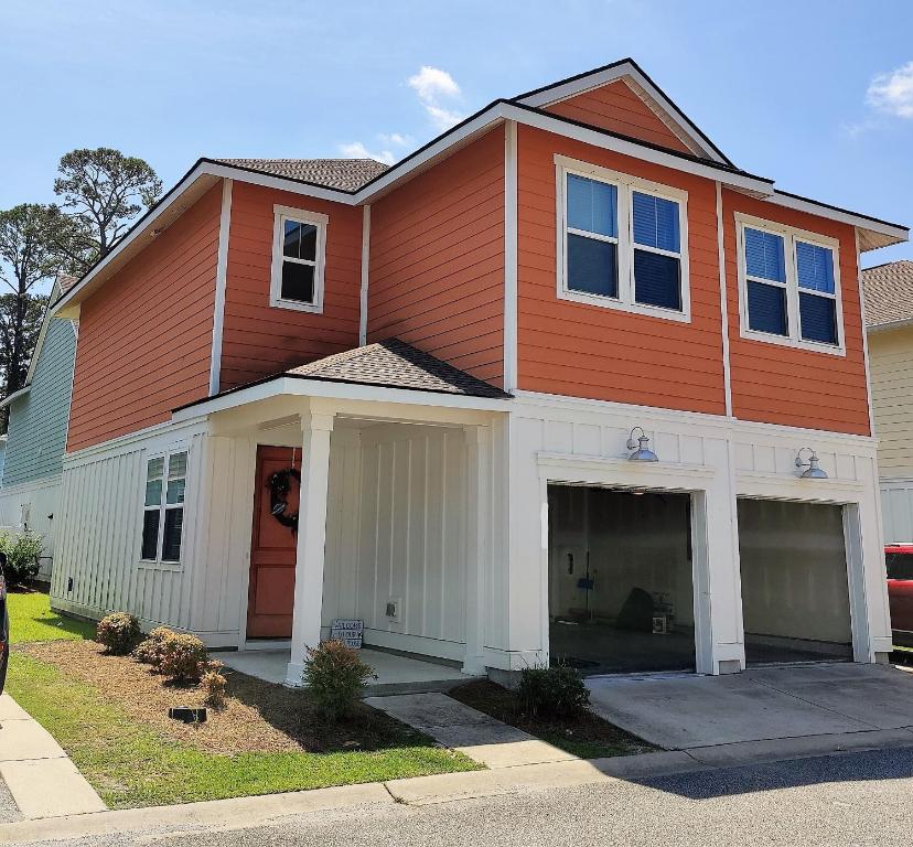 uma grande casa laranja e branca com garagem em Golf Resort, Beach, Entire House em Myrtle Beach