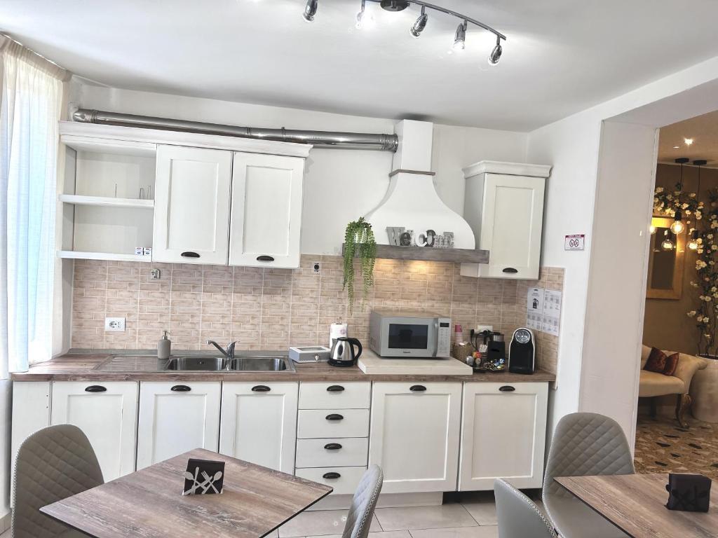 a kitchen with white cabinets and a table with chairs at Da Rita Affittacamere in Pisa