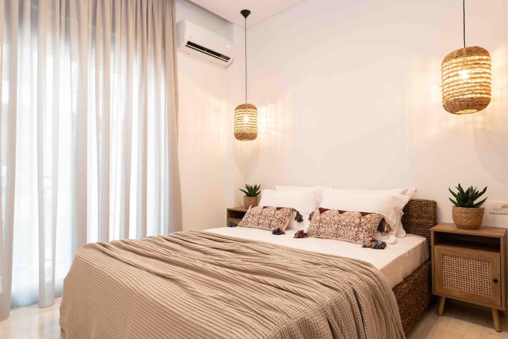 a bedroom with a bed and two pendant lights at Annmar in Zakynthos